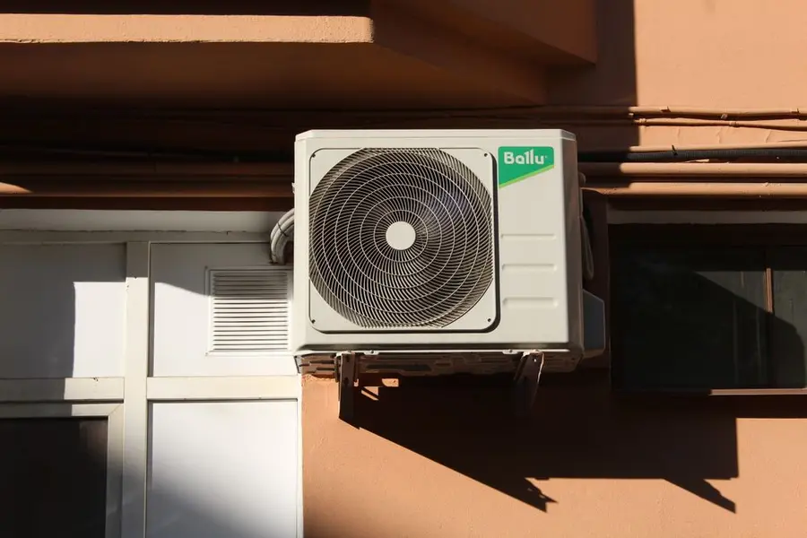 Unidad exterior de una bomba de calor de aerotermia instalada en el exterior de una vivienda
